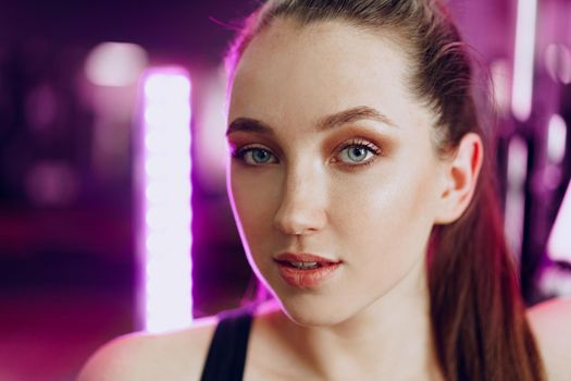 Portrait of a young sporty caucasian woman training in a fitness club close up