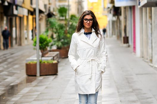 Portrait of a beautiful woman with eyesglasses walking in urban background