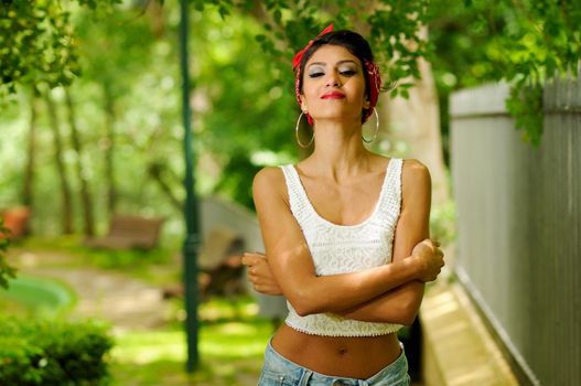 Portrait of a pin-up girl. American style, in a garden, wearing jeans and t-shirt