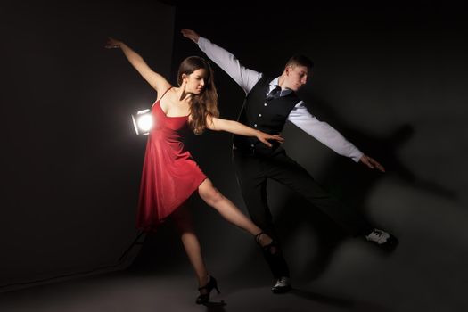 Man and woman in the most romantic dance tango over dark background