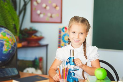 Young girl making science chemistry experiments in school laboratory. Education concept.