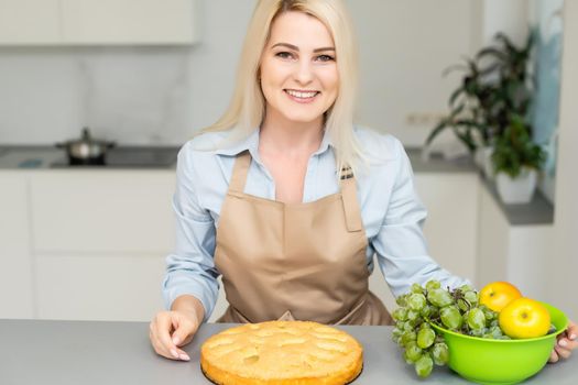 Beautiful woman holding pie in the kitchen