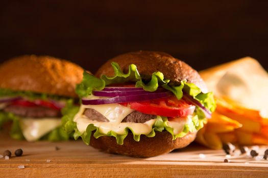 closeup of traditional cheeseburger or hamburger and french fries.