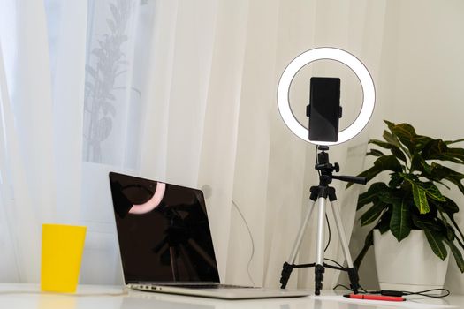 laptop, lamp and tripod on the table for online interview