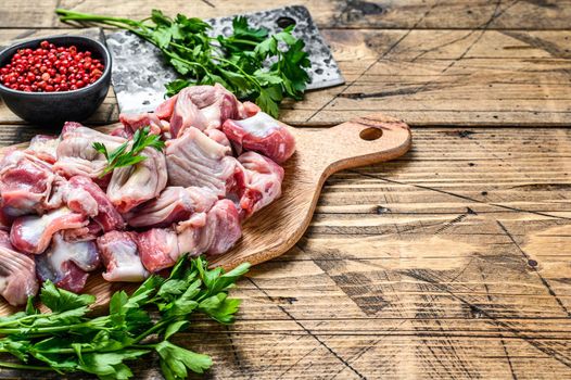 Raw uncooked chicken gizzards, stomach on a cutting board. wooden background. Top view. Copy space.