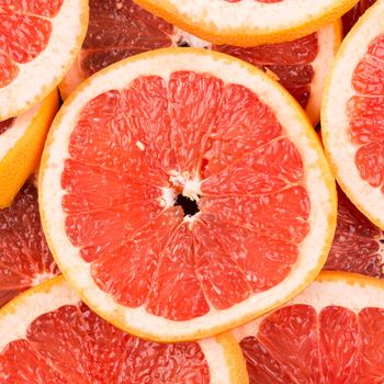 Abstract red background with citrus-fruit of grapefruit slices. Close-up