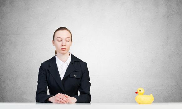 businesswoman at the table with a yellow toy duck