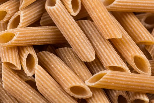 Wholemeal Pasta Penne as close-up shot for background