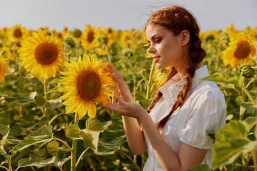 portrait of a woman in a field of sunflowers agriculture landscape nature. High quality photo
