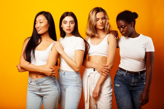 diverse multi nation girls group, teenage friends company cheerful having fun, happy smiling, cute posing on yellow background, lifestyle people concept, african-american, asian and caucasian close up