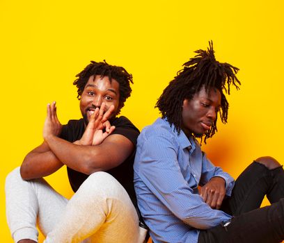 two african american guys posing cheerful together on yellow background, lifestyle people concept close up