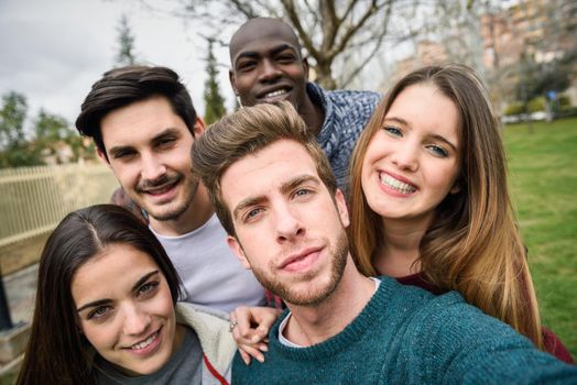 Multiracial group of friends taking selfie in a urban park