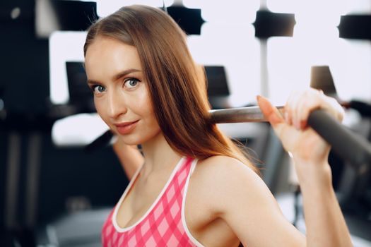 Close up photo of a young sporty woman working out in a gym