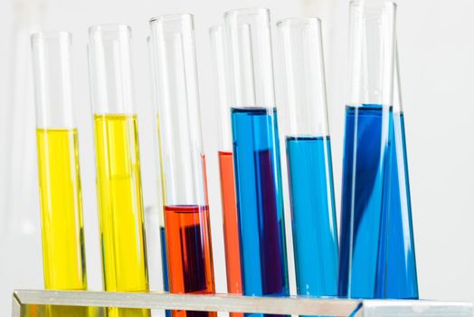 Science laboratory research and development. Close up test tubes with colorful substance on white background. Chemical manufacture concept with glass equipment. Modern biotechnology industry.