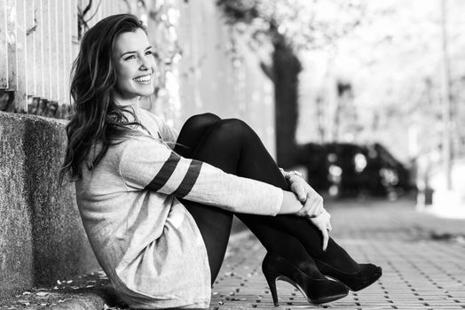 Portrait of funny female model of fashion with high heels sitting on the floor