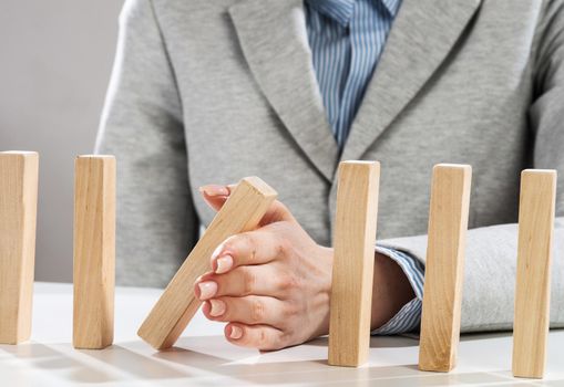 Business woman hand stop domino effect. Operative business solution, strategy and successful intervention. Life insurance company presentation with wooden blocks. Protection from economic crisis.