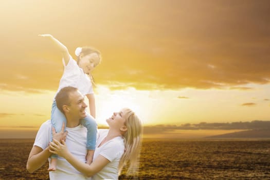 young happy family having fun outdoors, dressed in white and on sky and sunset