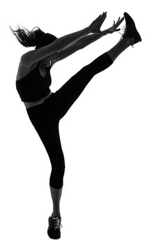 Portrait of woman doing martial arts kicking the air