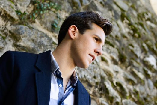 Portrait of handsome man with modern hairstyle in urban background