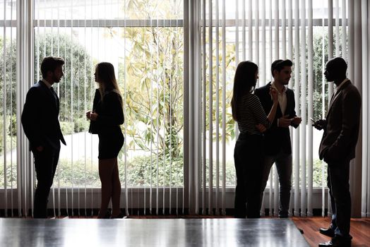 Several silhouettes of businesspeople interacting background business centrer