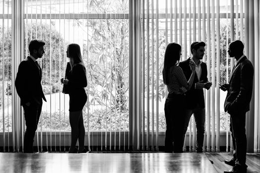 Several silhouettes of businesspeople interacting background business centrer