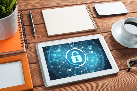 Business workplace with office stuff and tablet with padlock icons on screen