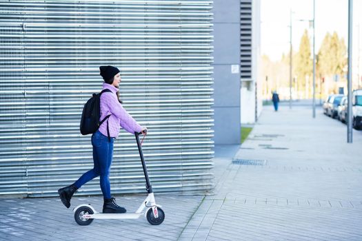Young woman in her twenties riding an electric scooter. Lifestyle concept.