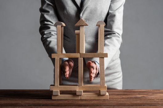 Business woman building construction on table from wooden blocks. Architecture engineering and construction. Company strategy planning, organization and development. Business motivation concept