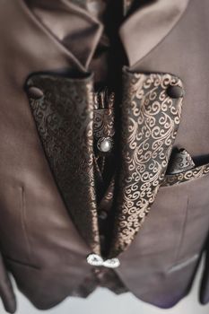 Luxury stylish brown men's suit with patterns and diamond clasp.