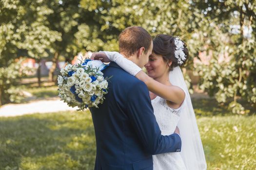 Belarus, Minsk region - August 11, 2018: Wedding. The hugs and tenderness of the happy bride and groom on a walk in the outdoor park background.