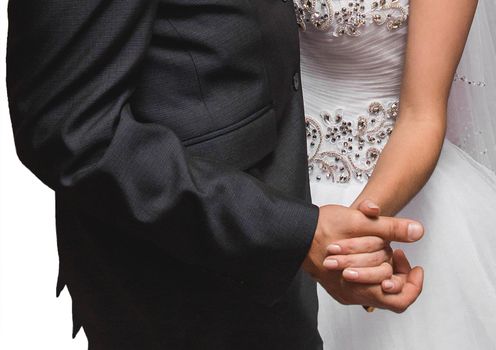 The bride and groom hold hands together tightly close-up at the wedding.