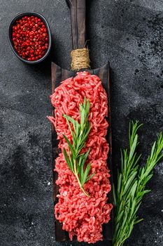 Fresh Raw mince beef, ground meat with herbs and spices. Black background. Top view.