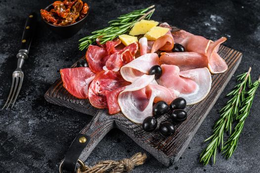 Set of smoked and dried meat Ham, jerky, salted meat, jamon and herbs. Black background. Top view.