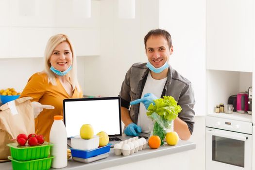 Laptop with blank white screen in kitchen. Culinary courses or recipe online. Cooking home concept. Food blog