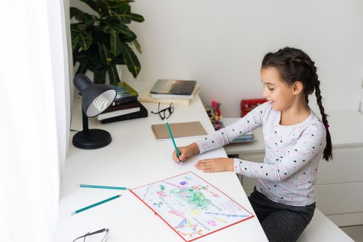 a child girl doing homework writing and reading at home