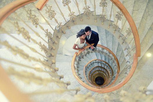 Just married couple together in a spiral staircase