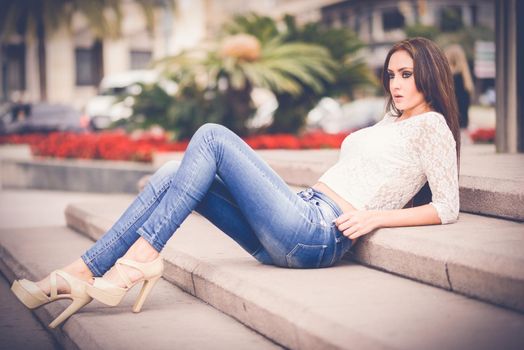 Portrait of a young woman, wearing casual clothes, with long hair in urban background