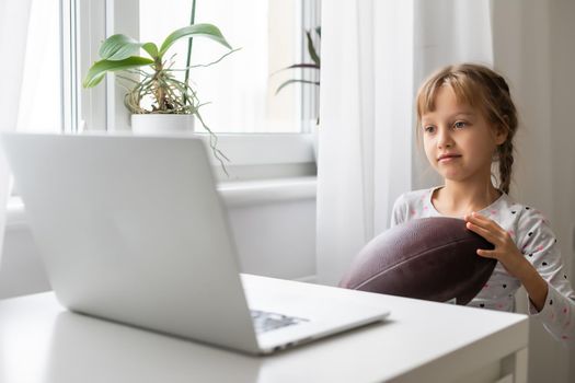 Internet addiction and computers concept with kid and laptop, little girl with rugby ball