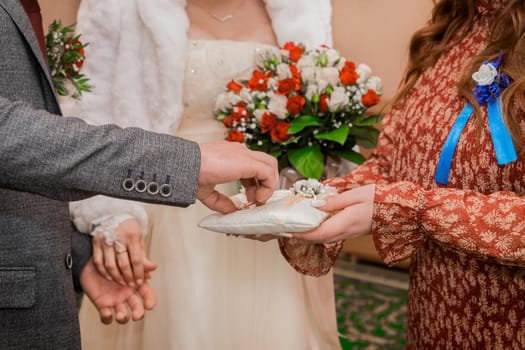 Witness's hands at wedding give groom marriage rings. Exchange of wedding rings.