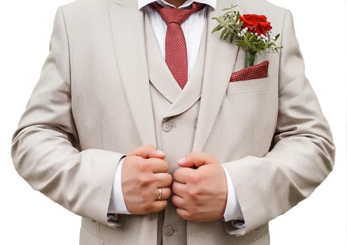 The groom's light beige suit holds hands with a boutonniere and a red tie isolated white background close-up.