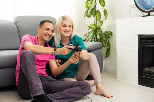 Man and woman playing video games with joystick at home.