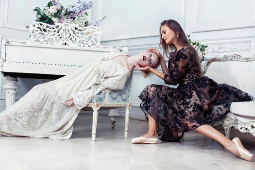 young pretty brunette ballet dancer at piano with blond woman in luxury royal interior, lifestyle rich people concept closeup