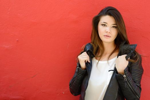 Portrait of beautiful japanese woman in urban background wearing leather jacket