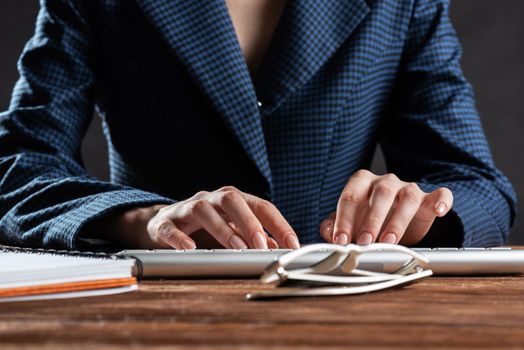Close up woman hands lying on laptop keyboard. Business lady working with computer at wooden desk. Financial specialist working at workplace in office. Human resources and career development.