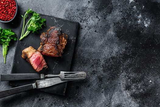 Grilled Striploin or new york steak. Black background. Top view. Copy space.