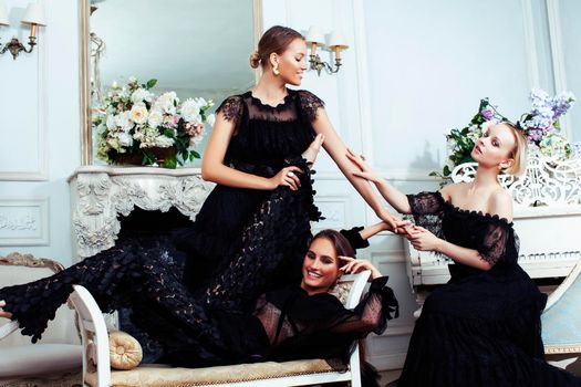 tree young pretty lady in black lace fashion style dress posing in rich interior of royal hotel room, luxury lifestyle people concept closeup