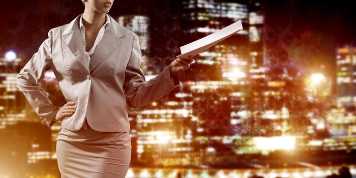 Businesswoman wearing modern suit and holding contract or report in her hand