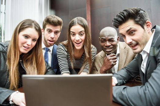 Businesspeople, teamwork. Group of multiethnic busy people looking at a laptop