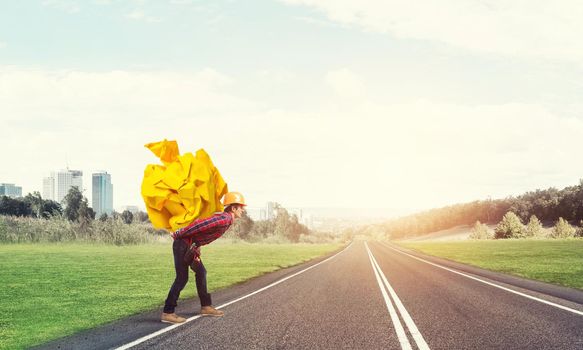 Builder man carrying paper ball on his back