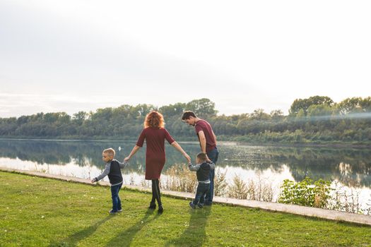 People and nature concept - Family walking by the water.